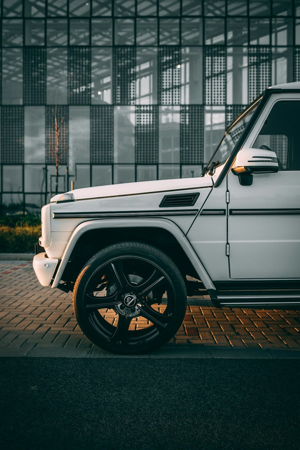 White luxury vehicle parked outside estate